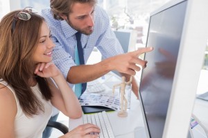 Man pointing something to his partner on screen in creative office